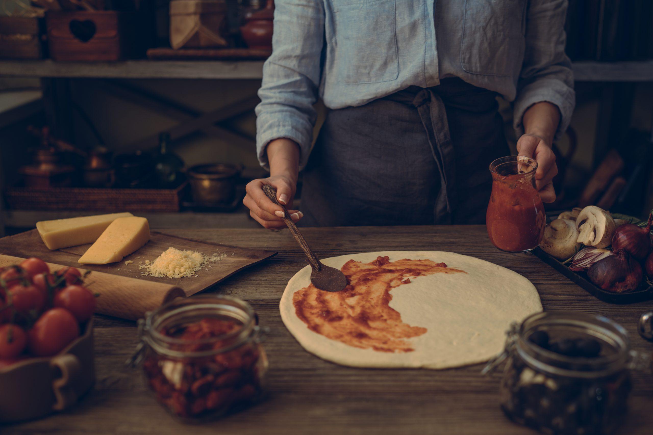 Person Preparing Homemade Pizza