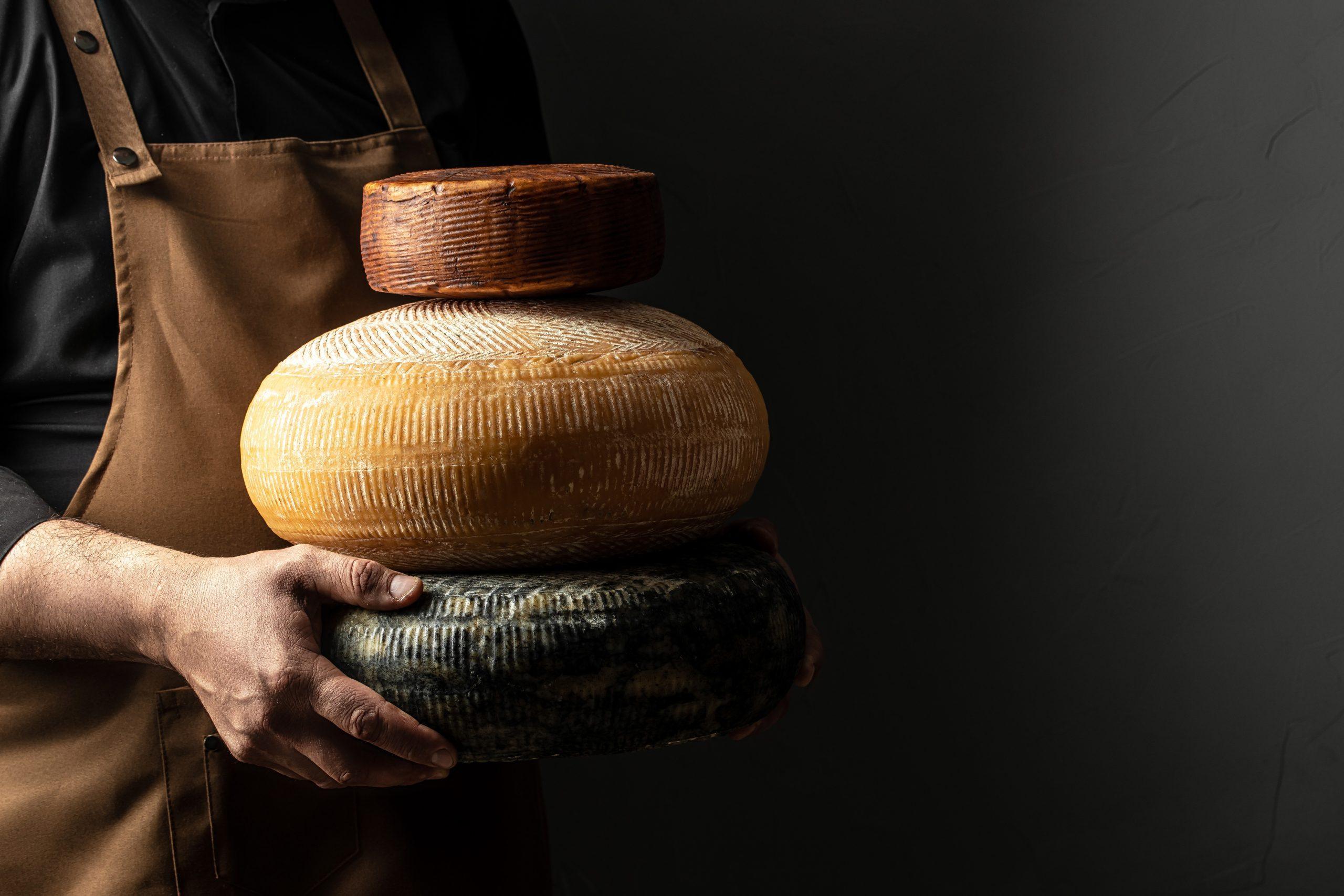 Person Holding a Stack of Cheese Indoors
